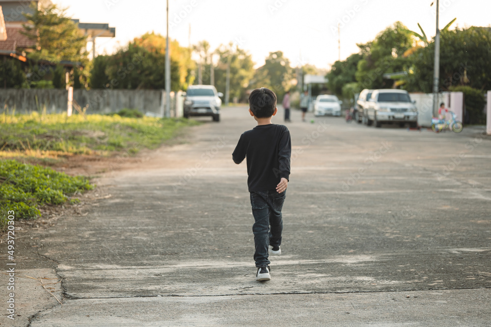 Asian boy running to his friend and having fun while playing outdoor.