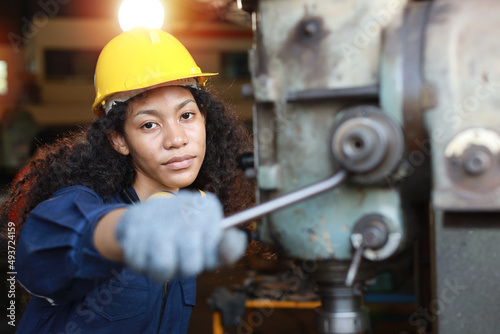 Wallpaper Mural Technician engineer or worker woman in protective uniform with safety hardhat maintenance operation or checking lathe metal machine at heavy industry manufacturing factory. Metalworking concept Torontodigital.ca