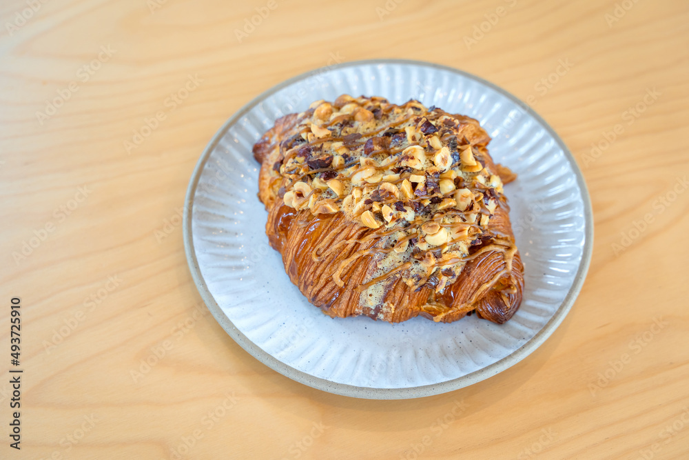Roasted Hazelnut Coffee Croissant is a delicious homemade bakery on a wooden table. Traditional French breakfasts crispy croissants baked pastries are favorited worldwide. Roasted Hazelnut Coffee Croissant is a delicious homemade bakery on a wooden table. Traditional French breakfasts crispy croissants baked pastries are favorited worldwide.