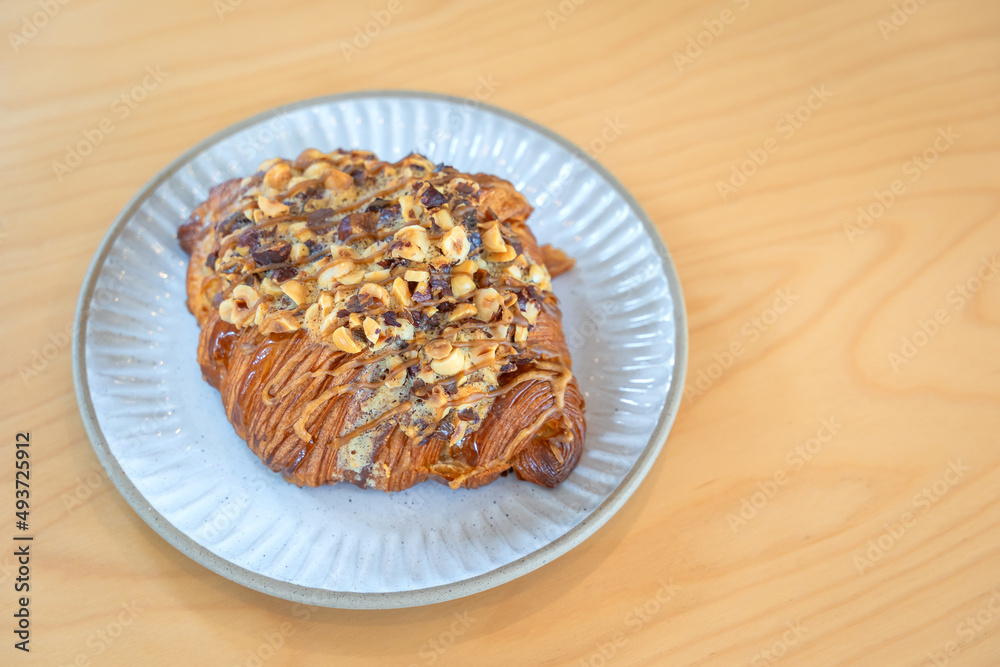 Roasted Hazelnut Coffee Croissant is a delicious homemade bakery on a wooden table. Traditional French breakfasts crispy croissants baked pastries are favorited worldwide. Roasted Hazelnut Coffee Croissant is a delicious homemade bakery on a wooden table. Traditional French breakfasts crispy croissants baked pastries are favorited worldwide.