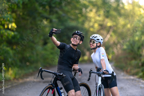 happy couple cycle selfie with smart phone during ride on rode in countryside for health life style