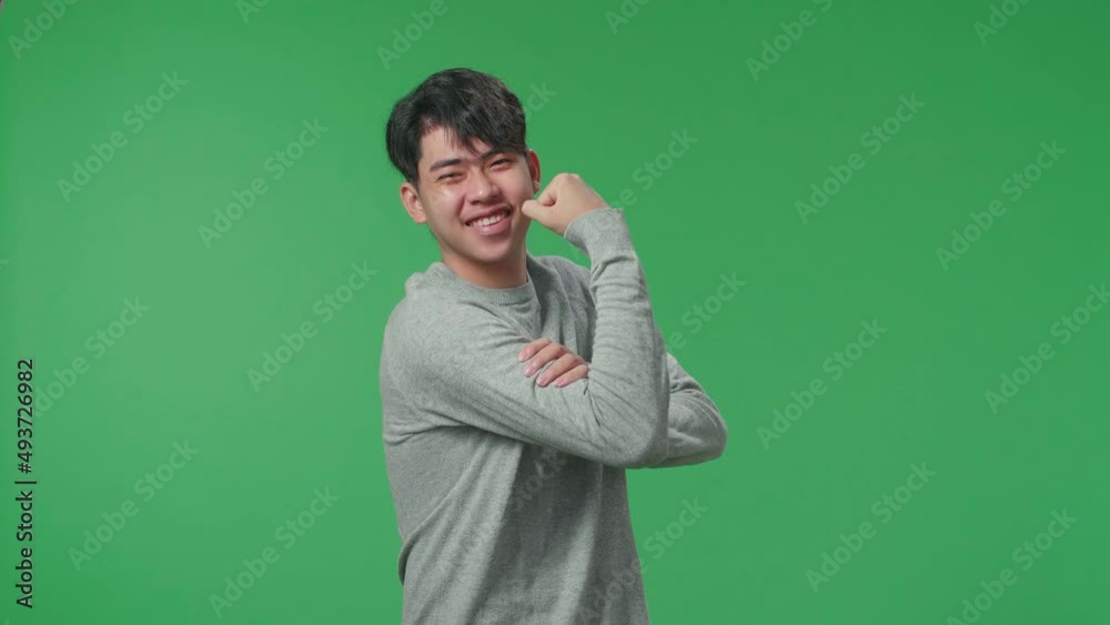 Side View Of A Smiling Asian Man Flex Muscle While Standing In Front Of Green Screen Background
Side View Of A Smiling Asian Man Flex Muscle While Standing In Front Of Green Screen Background