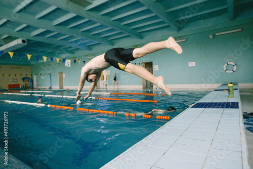 Male swimmer jumping in a swimming pool