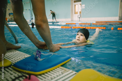 Girl learning to swim with coach at the leisure center