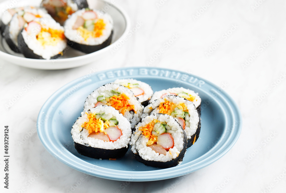 Korean Roll Gimbap (Kimbob or Kimbap) made from Steamed White Rice (Bap) and Various other Ingredients, Such As Kyuri, Carrot, Sausage, Crab Stick, or Kimchi and Wrapped with Seaweed Laver Korean Roll Gimbap (Kimbob or Kimbap) made from Steamed White Rice (Bap) and Various other Ingredients, Such As Kyuri, Carrot, Sausage, Crab Stick, or Kimchi and Wrapped with Seaweed Laver