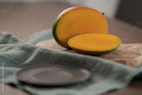 Freshly cut ripe mango on olive board photo
