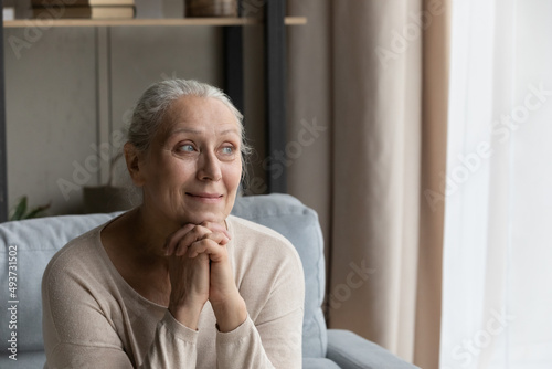 Quadro em tela Peaceful older woman resting alone at home, having nostalgic mood looking serene