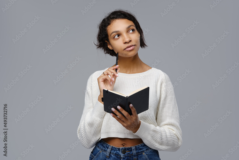 Young african woman recalls past events to write in a diary Young african woman recalls past events to write in a diary