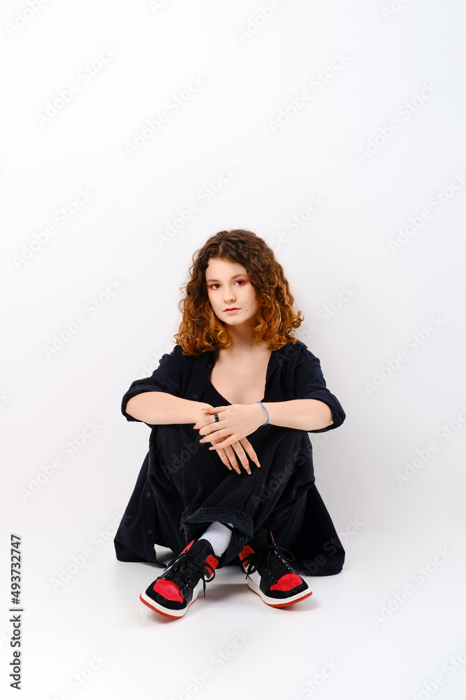 Cute girl sitting in studio on the floor Cute girl sitting in studio on the floor