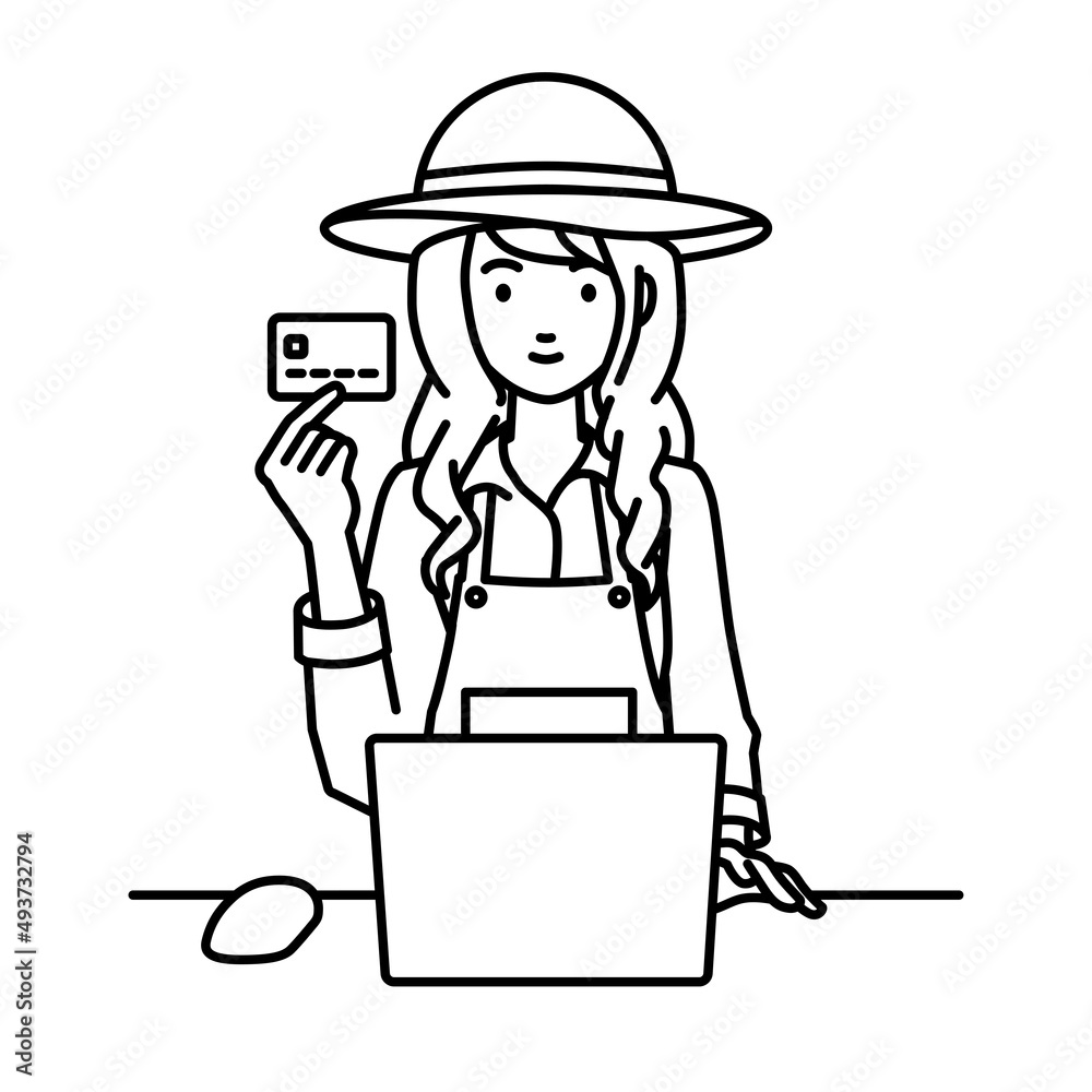 デスクで座ってPCを使いながらクレジットカードを手に持っている農家の女性