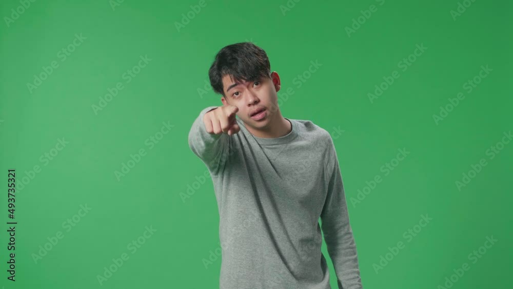 An Angry Asian Man Scolding While Standing On Green Screen In The Studio
