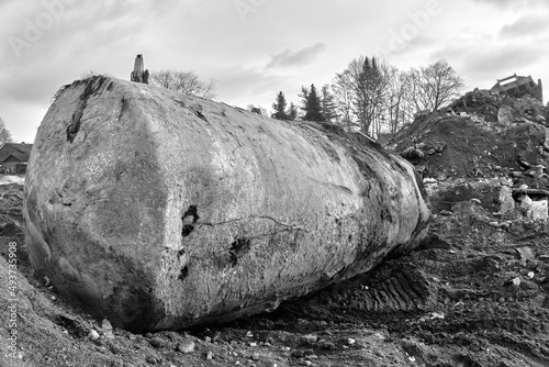 Excavated earth tank for oil and gasoline next to a hill with construction debris and excavated soil