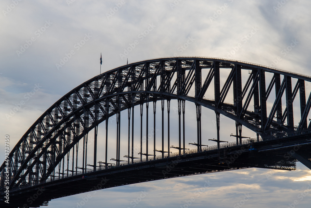 Close-up view of Sydney Harbour Bridge with cloudy sky.