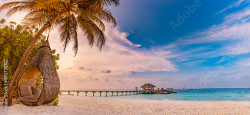 Fototapeta Naklejka Na Ścianę i Meble -  Tropical sunset beach panorama as summer landscape with relax beach swing or hammock on coconut palm, white sand and calm sea beach banner. Perfect beach vacation or summer holiday panoramic concept