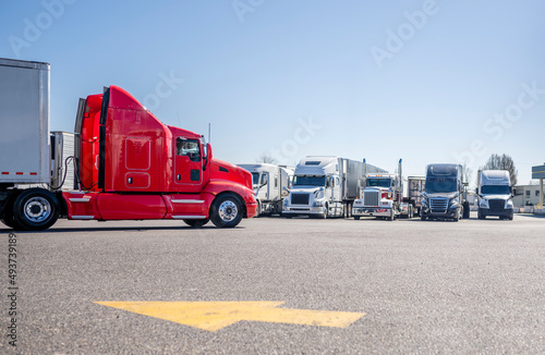 Photo Bright red big rig semi truck with extended cab transporting cargo in dry van se