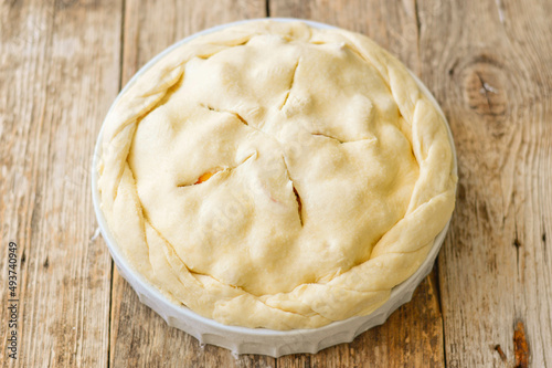 Raw Tart dough, shortcrust pastry with cutted apples, in ceramic tart pan. Baking an apple pie. Step by step recipe