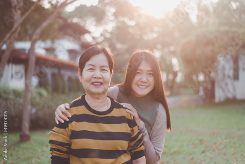 Asian mature mother happy with hand daughter take care and support at outdoor,Health insurance and elderly care,Family caregiving concept photo