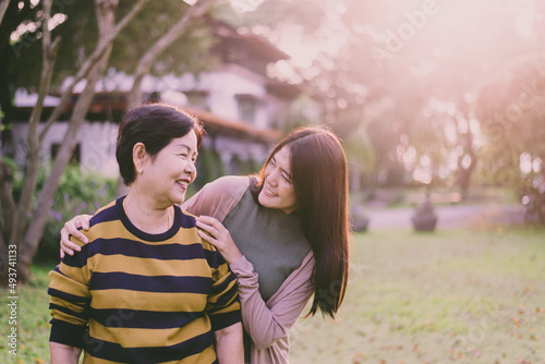 Asian elderly mother happy with hand daughter take care and support at outdoor,Health insurance and elderly care,Family caregiving concept