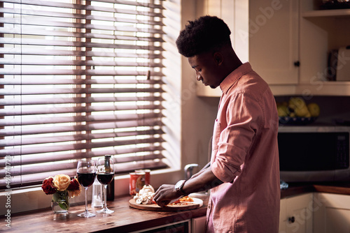 Hes going to spoil his lady today. Cropped shot of handsome romantic young man preparing a meal on Valentines day at home.