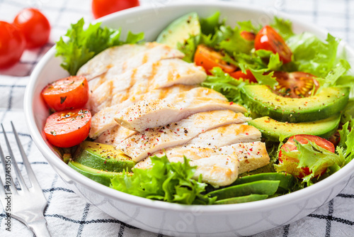 Grilled chicken breast salad with avocado and cherry tomatoes. Healthy diet food concept.