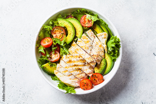 Grilled chicken breast salad with avocado and cherry tomatoes. Healthy diet food concept.