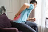 Back pain, kidney inflammation, man suffering from backache at home