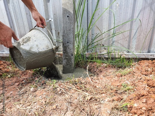 Dig a deep hole in the soil to pour mortar on the fence posts to strengthen the foundation.