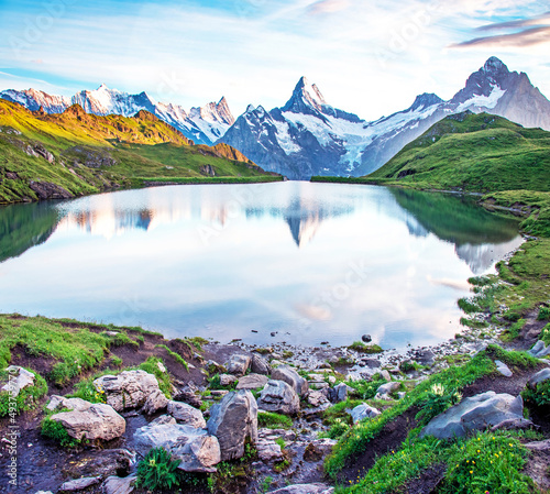 Obraz na płótnie Fantastic landscape at sunrise with stones in the foreground on the lake in the Swiss Alps. Wetterhorn, Schreckhorn, Finsteraarhorn et Bachsee. Exciting places. (relaxation, harmony - concept). w salonie