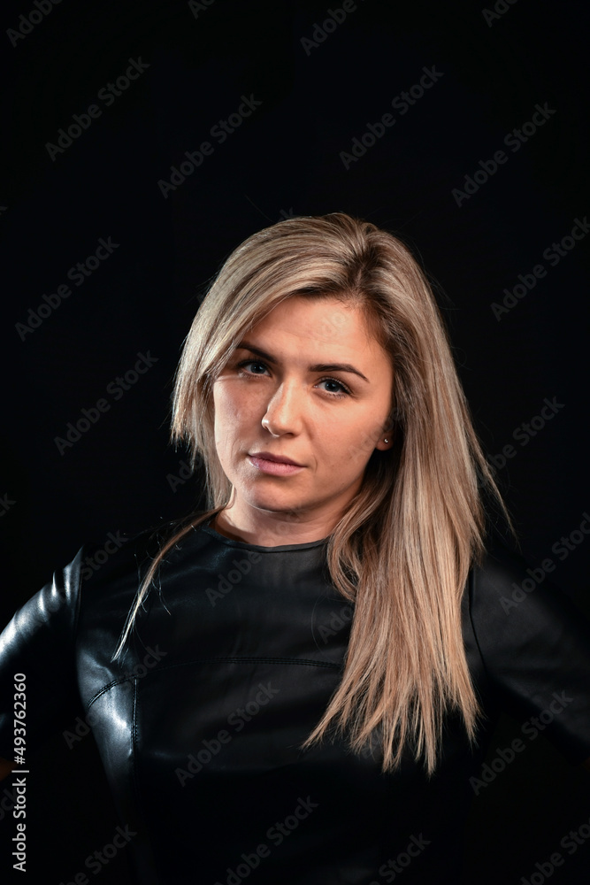 Young blond woman of white race with long hair. Studio photo on a dark background Young blond woman of white race with long hair. Studio photo on a dark background