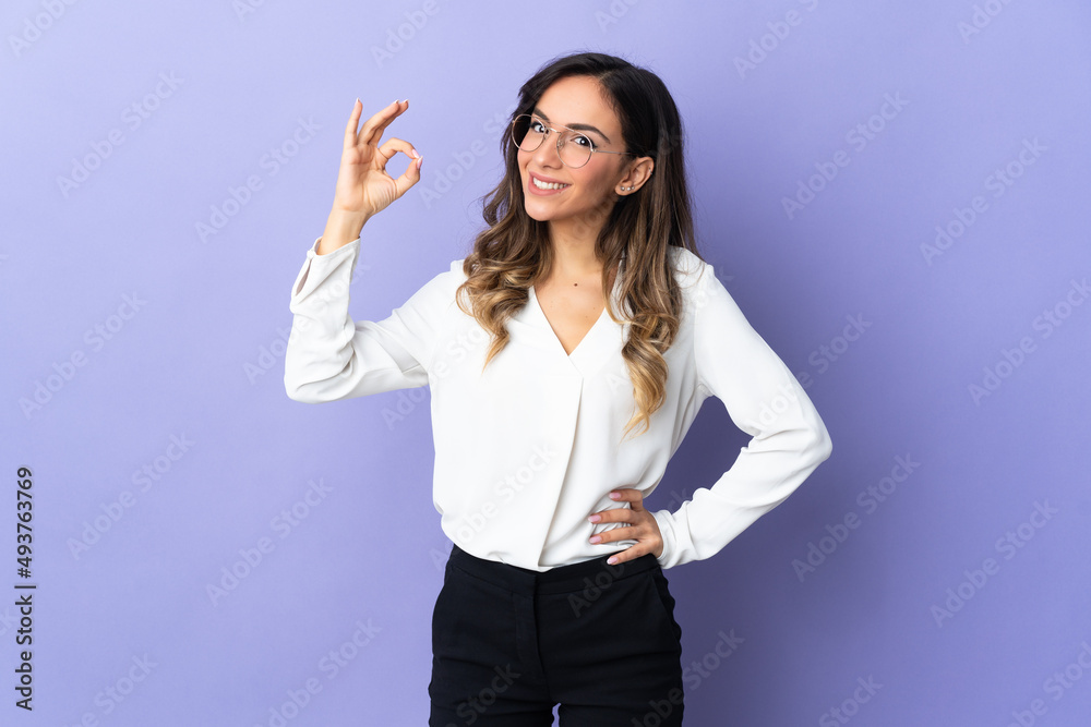 Young caucasian woman isolated on purple background showing ok sign with fingers