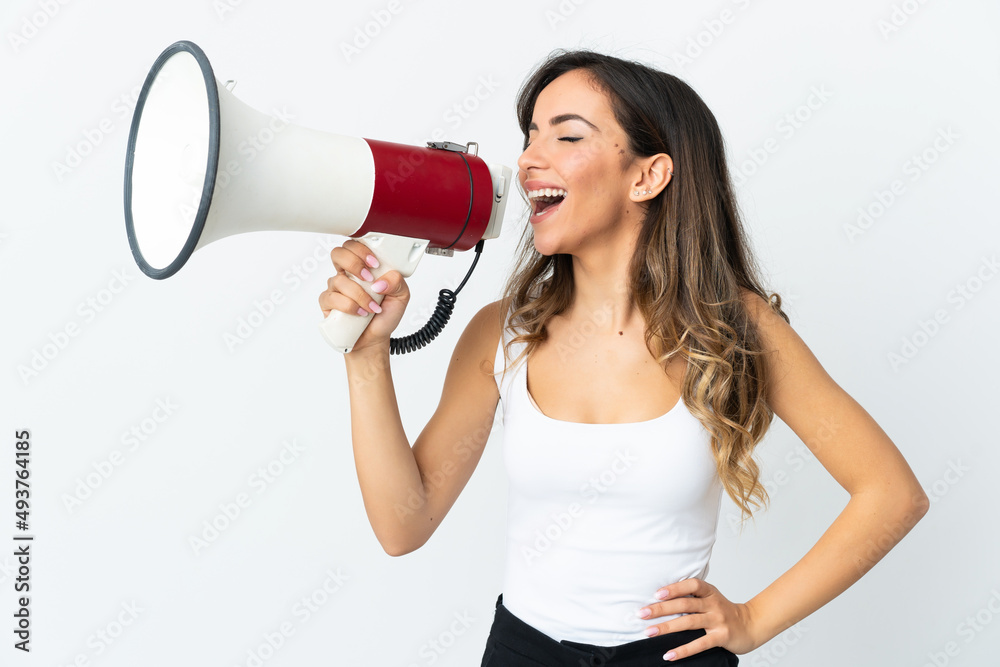 Young caucasian woman isolated on white background shouting through a megaphone to announce something in lateral position Young caucasian woman isolated on white background shouting through a megaphone to announce something in lateral position