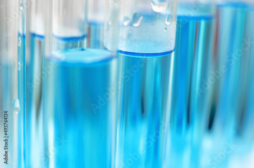 Laboratory test tubes with blue liquid close up, selective focus. Scientific laboratory research and experiments.