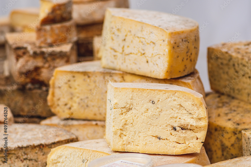 Variety of homemade bio natural seasoned cheese in a street food market ready to eat, close up