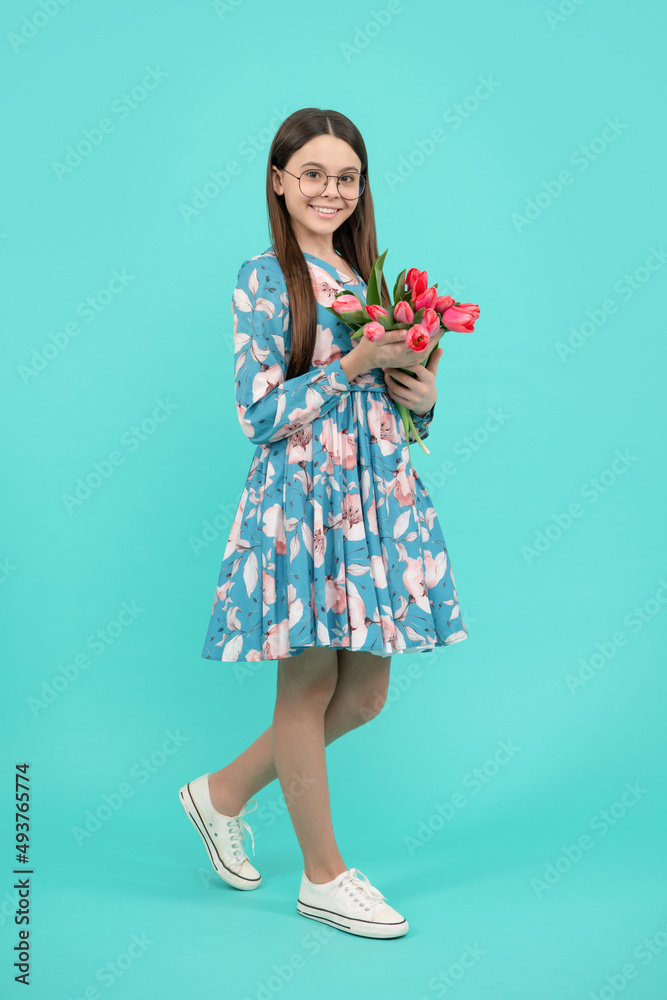 happy child in glasses with tulips. mothers or womens day. kid hold flowers for 8 of march happy child in glasses with tulips. mothers or womens day. kid hold flowers for 8 of march