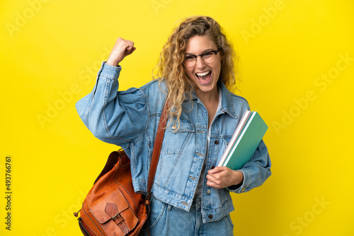 Young student caucasian woman isolated on yellow background doing strong gesture photo