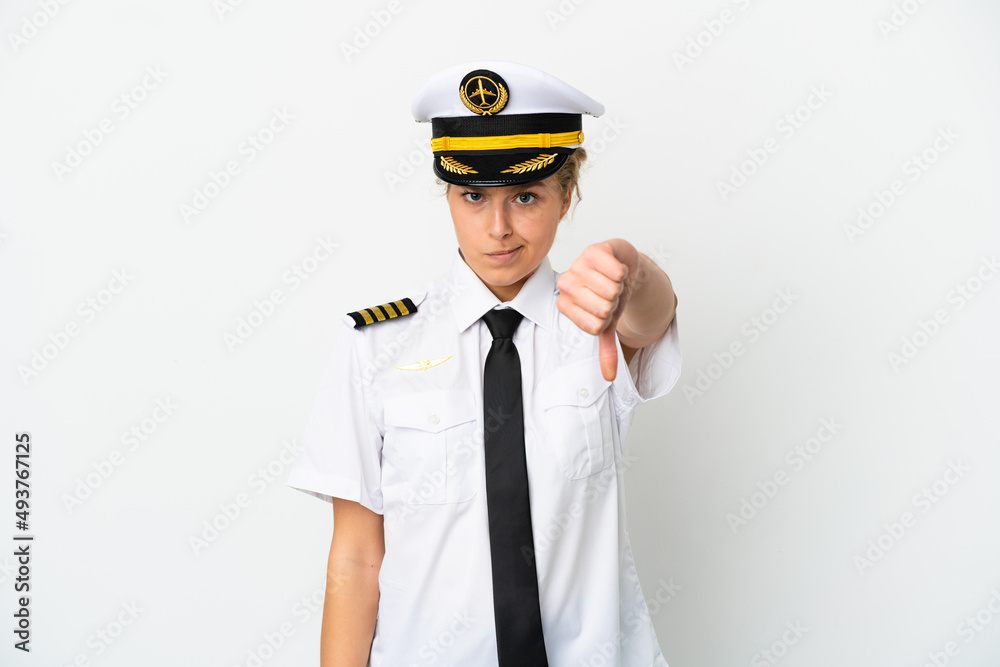 Airplane blonde woman pilot isolated on white background showing thumb down with negative expression