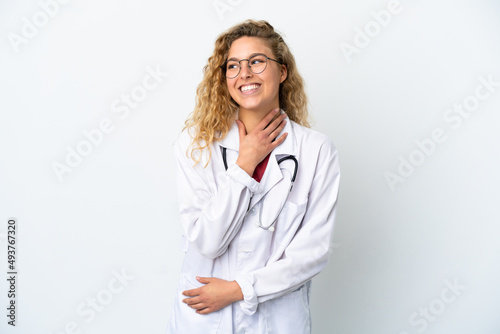 Young doctor blonde woman isolated on white background looking up while smiling