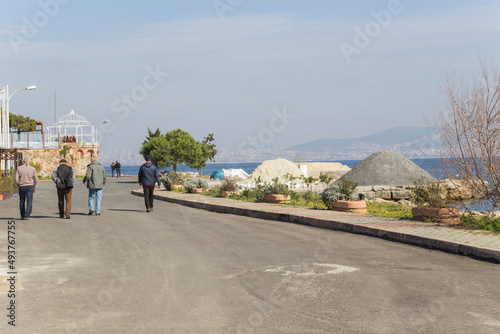 Beautiful view of three men walking on an empty road near the beach burgazada ıstanbul, turkey photo