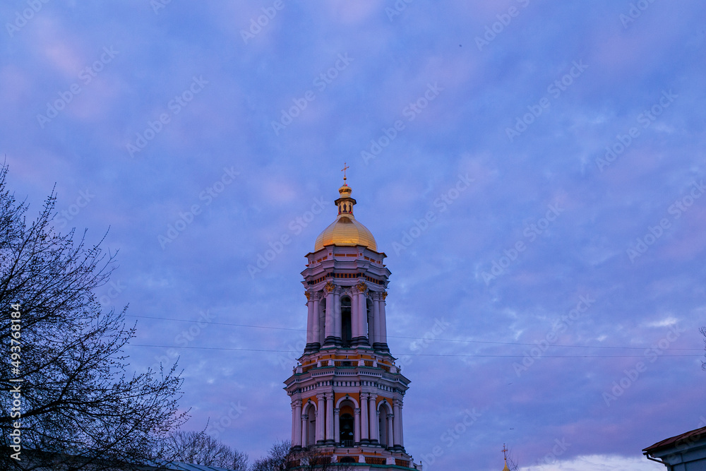 Medieval Gate Church of the Trinity of Kyiv Pechersk Lavra. View of east facade from the monastery side on a background of blue sky with clouds in winter. Medieval Gate Church of the Trinity of Kyiv Pechersk Lavra. View of east facade from the monastery side on a background of blue sky with clouds in winter.
