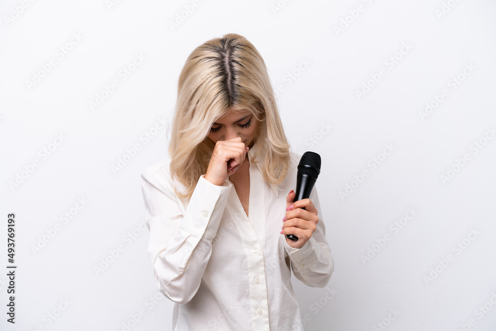 Young singer woman picking up a microphone isolated on white background having doubts Young singer woman picking up a microphone isolated on white background having doubts