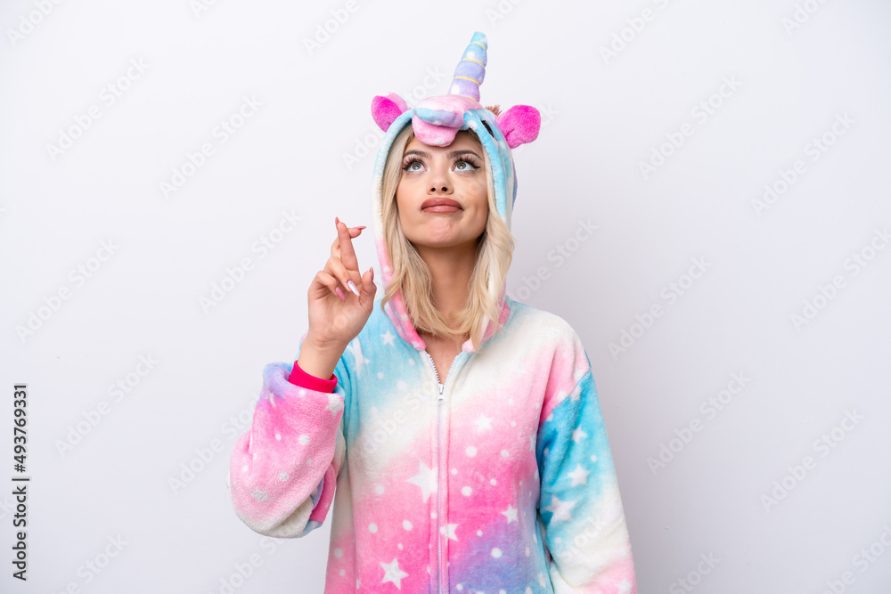 Young Russian woman with unicorn pajamas isolated on white background with fingers crossing and wishing the best Young Russian woman with unicorn pajamas isolated on white background with fingers crossing and wishing the best
