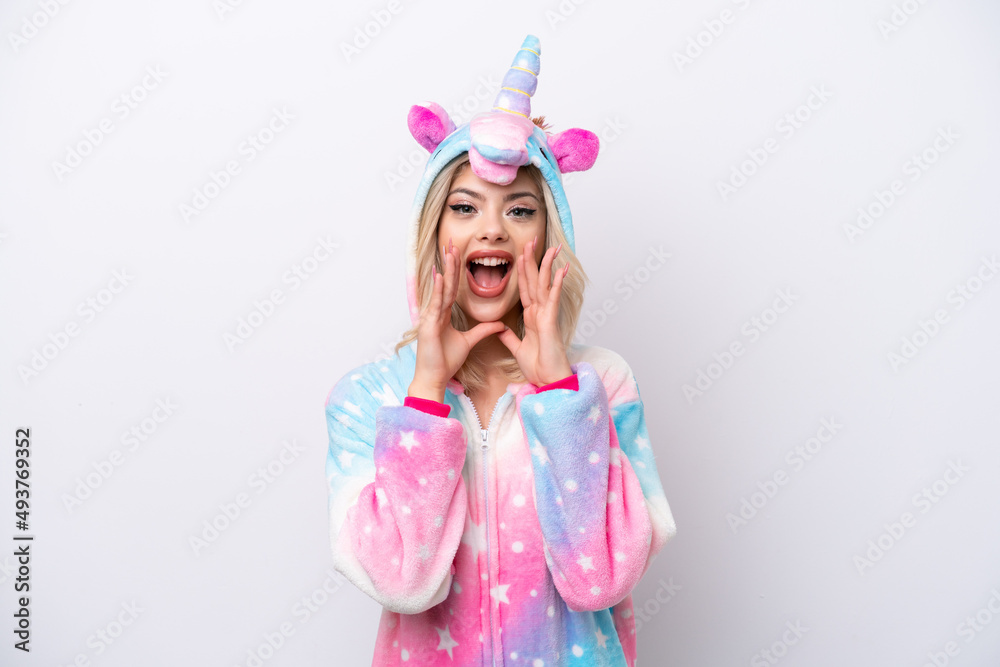 Young Russian woman with unicorn pajamas isolated on white background shouting and announcing something Young Russian woman with unicorn pajamas isolated on white background shouting and announcing something