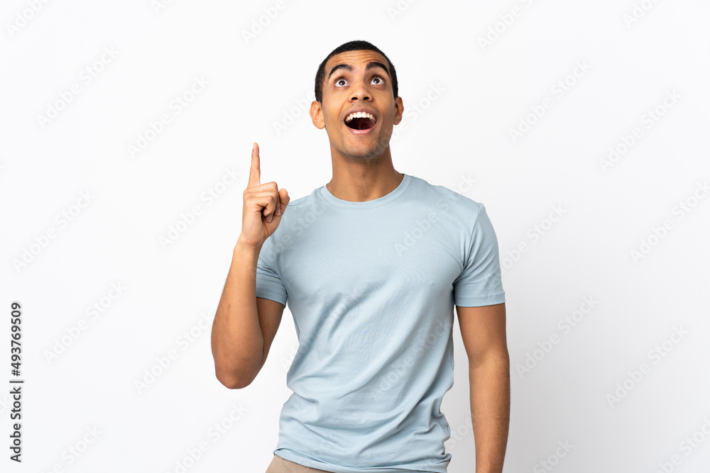 African American man over isolated white background pointing up and surprised African American man over isolated white background pointing up and surprised