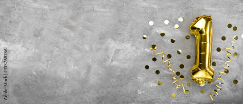 Yellow foil balloon number, number one on a concrete background. Birthday card with lettering 1. Anniversary concept. for anniversary, birthday, new year celebration.
