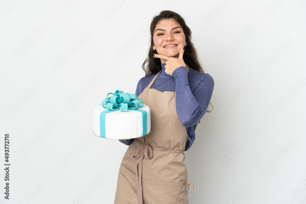 Pastry Russian chef holding a big cake isolated on white background happy and smiling Pastry Russian chef holding a big cake isolated on white background happy and smiling