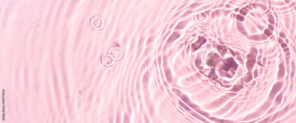 Texture of drops on pink water under sunlight. Top view, flat lay. Banner Texture of drops on pink water under sunlight. Top view, flat lay. Banner