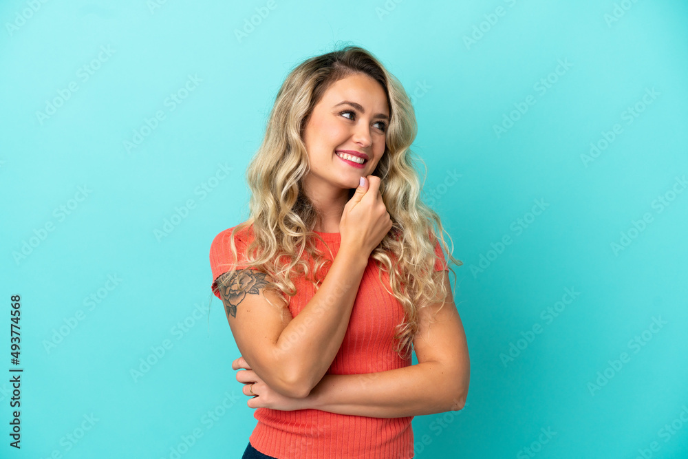 Young Brazilian woman isolated on blue background looking to the side and smiling Young Brazilian woman isolated on blue background looking to the side and smiling