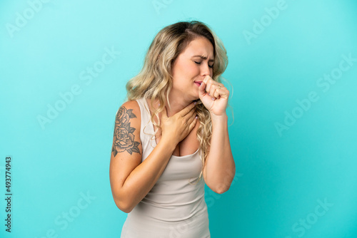 Young Brazilian woman isolated on blue background coughing a lot