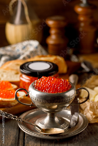 Red Caviar with bread and butter, with great background, glass, Jar, with glass of wine. photo