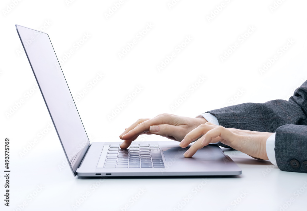 Close up of business woman in suit typing on portable laptop while sitting in white studio. Female entrepreneur working on modern computer. Close up of business woman in suit typing on portable laptop while sitting in white studio. Female entrepreneur working on modern computer.